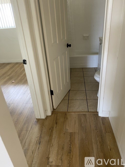 A hallway with a wooden floor and white walls.