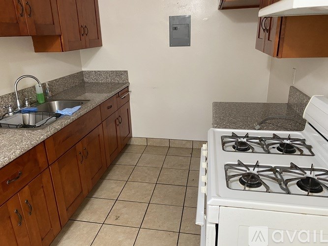 A kitchen with a white stove and wooden cabinets.