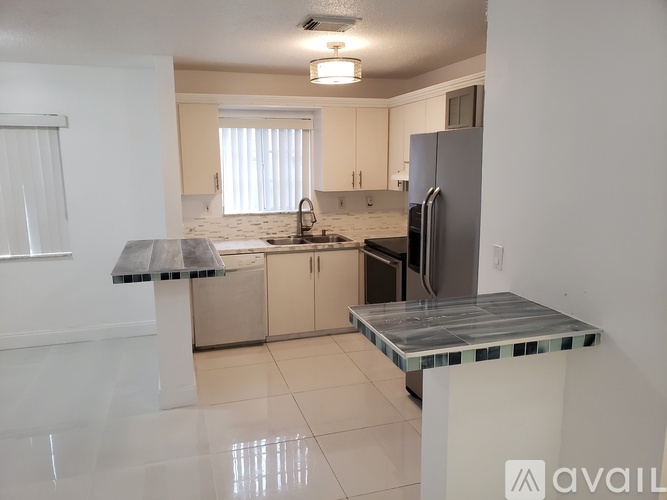 A kitchen with a marble island in the middle.