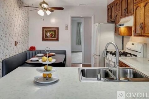 A kitchen with a table set for two and a fridge in the background.