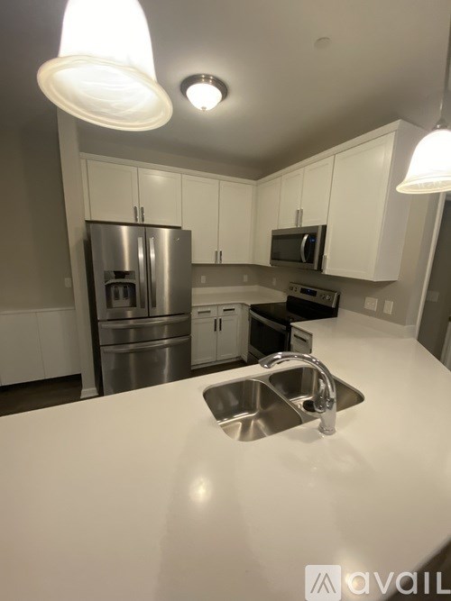 A kitchen with a stainless steel refrigerator and white cabinets.