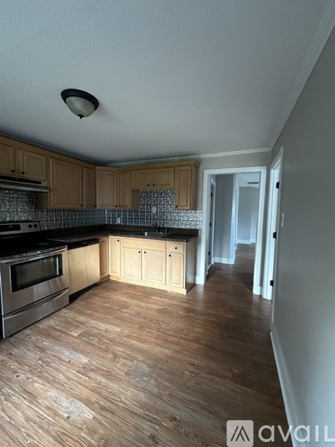A kitchen with wooden cabinets and a black stove top oven.