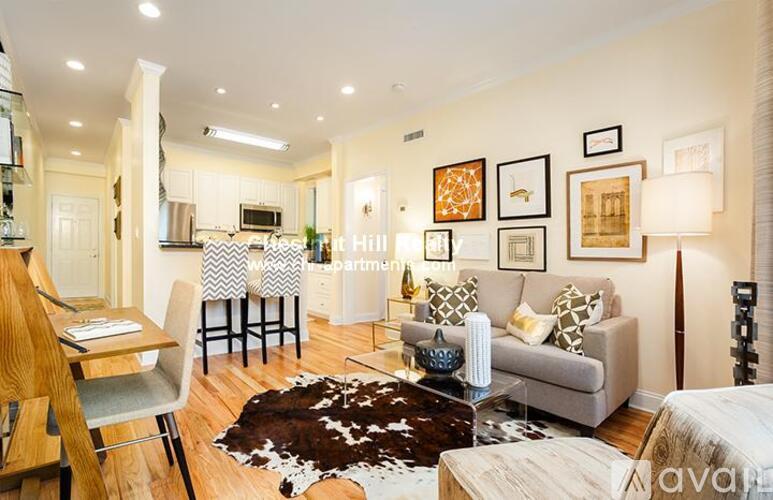 A living room with a couch, chair, and pictures on the wall.
