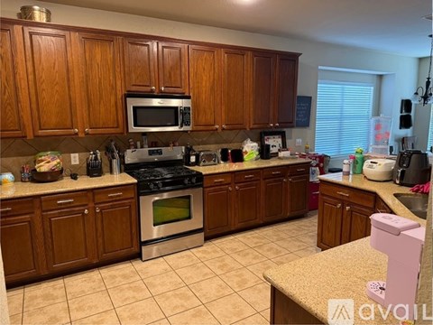 A kitchen with wooden cabinets and a black stove top oven.