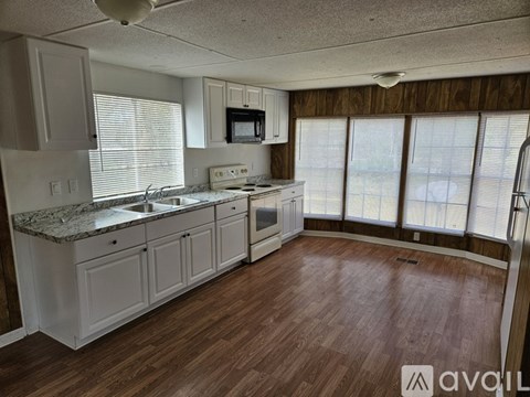 A kitchen with white cabinets and a granite countertop.