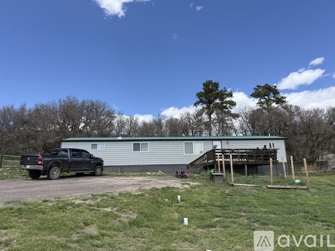 A truck is parked in front of a house with a metal roof.