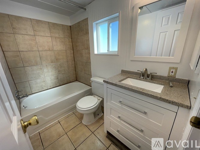 A bathroom with a tub, toilet, and sink.