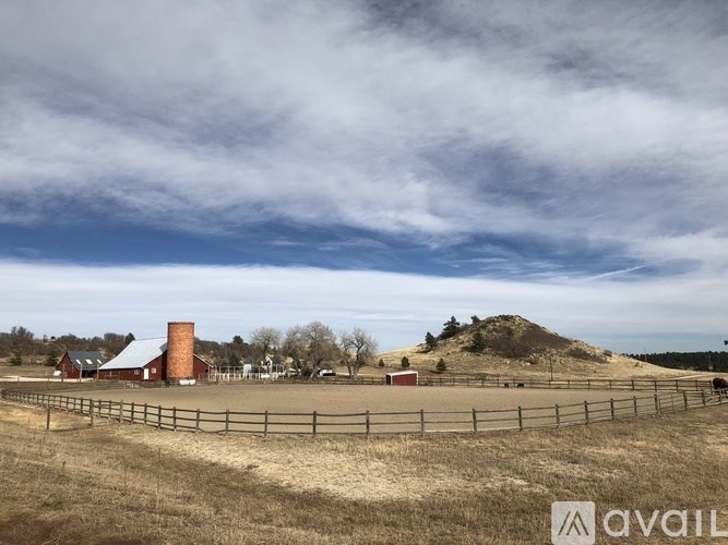 A farm with a red barn and a fence in the foreground.