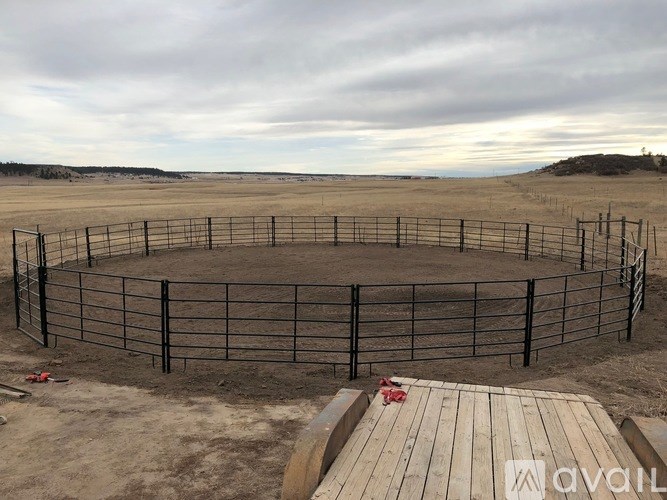 A fenced area with a wooden deck in the foreground.