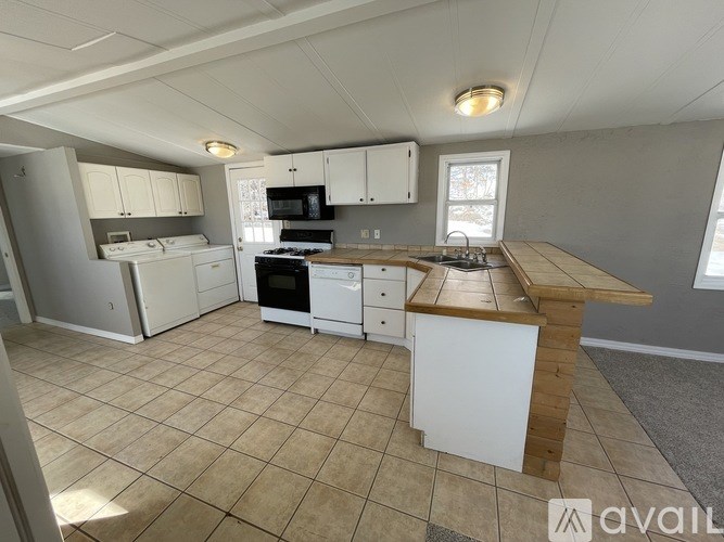 A kitchen with white appliances and a wooden island.