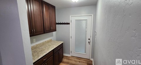 A kitchen with brown cabinets and a white door.