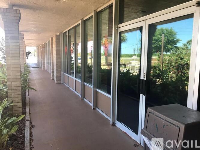 A long hallway with glass doors and a trash can.