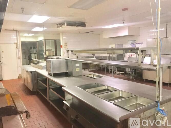 A clean, empty commercial kitchen with stainless steel appliances and counters.