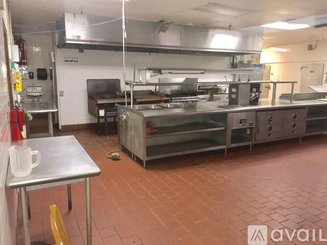 A kitchen with a table and a stainless steel oven.