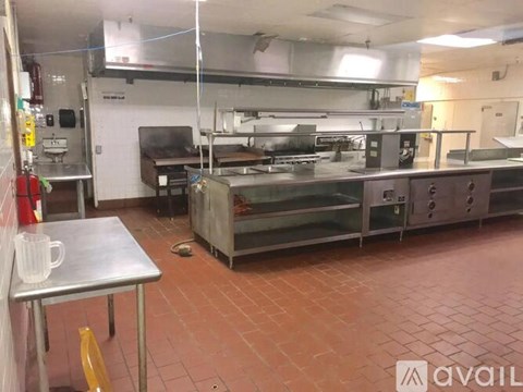 A kitchen with a table and a stainless steel oven.