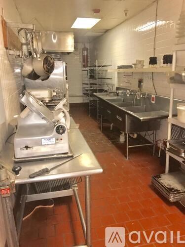 A kitchen with a red floor and a stainless steel counter.