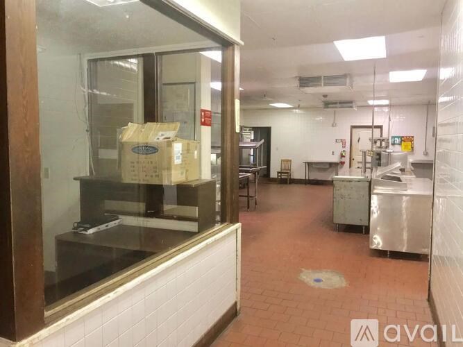 A kitchen area with a glass window and a tiled floor.