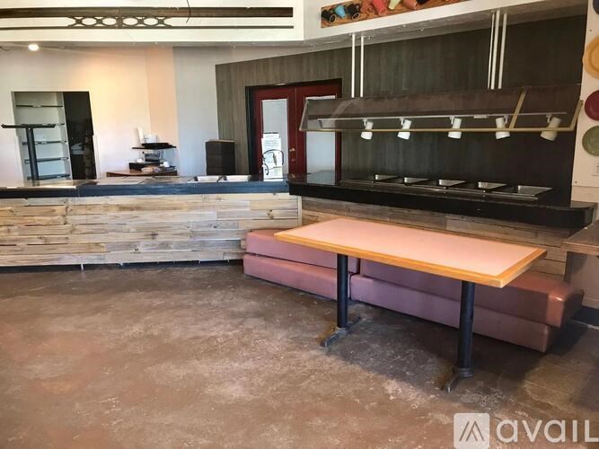 A room with a wooden bench and a counter with a shelf above it.