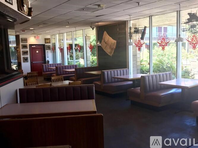 A restaurant with a brown booth and a red door.