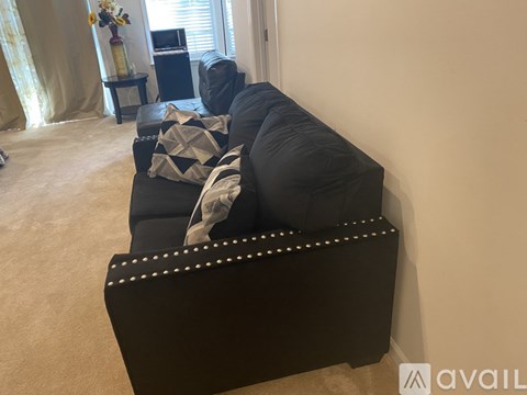 A black sofa with studded trim sits in a living room.