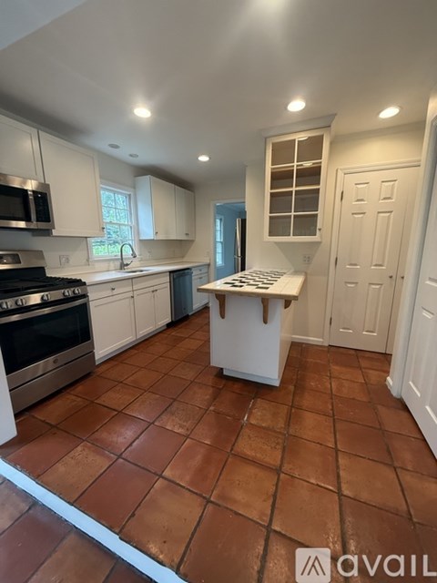 A kitchen with brown tiles on the floor.