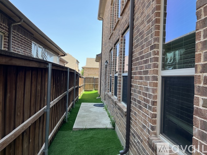 A narrow alley between two brick buildings with a concrete pathway.