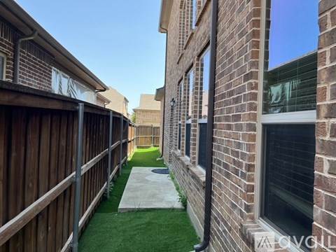 A narrow alley between two brick buildings with a concrete pathway.