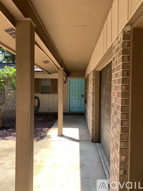 A blue door is on the right side of a brick wall.