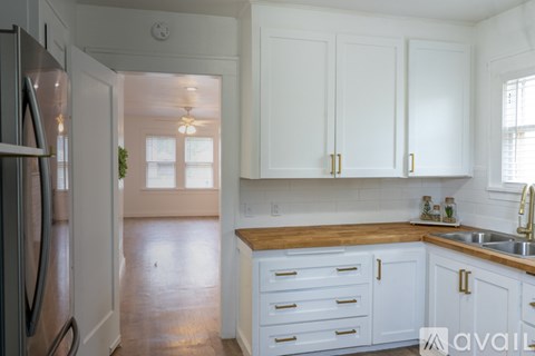 A kitchen with white cabinets and a wooden countertop.