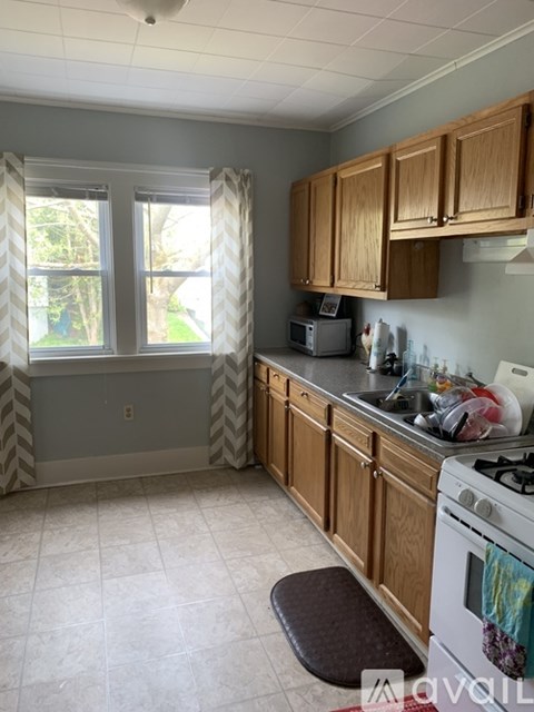 A kitchen with wooden cabinets and a white stove top oven.