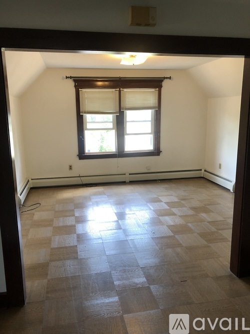 A room with a window and wooden flooring.
