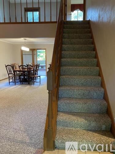 A staircase with a carpeted runner and wooden banister.
