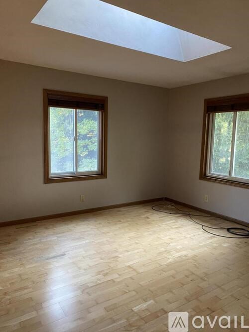 A room with wooden flooring and skylight windows.