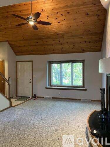 A room with a ceiling fan and a window.