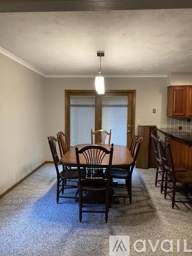 A dining room with a table and chairs.