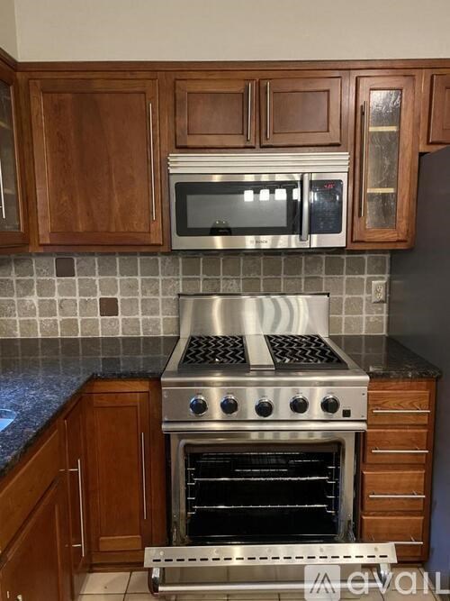 A kitchen with a stove top oven and microwave above it.