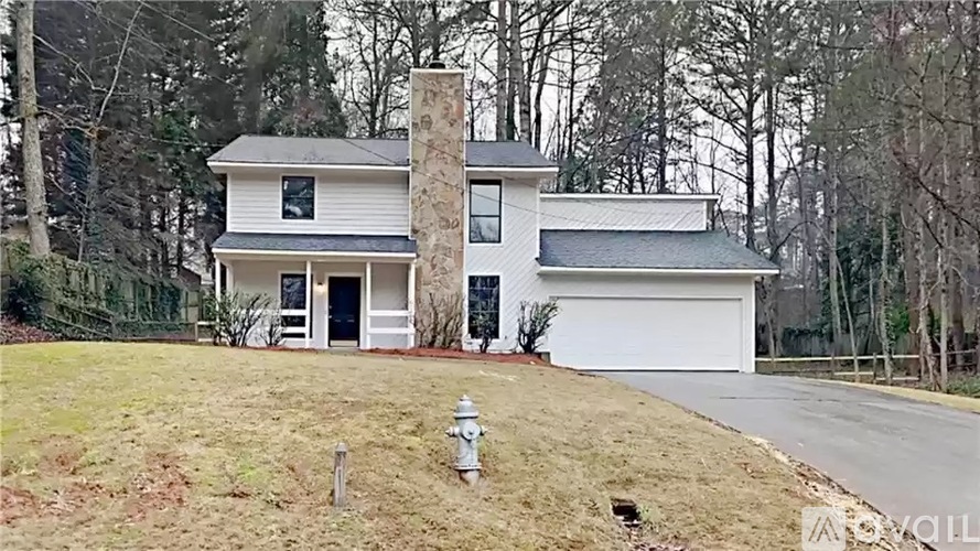 A white house with a chimney and a garage door.