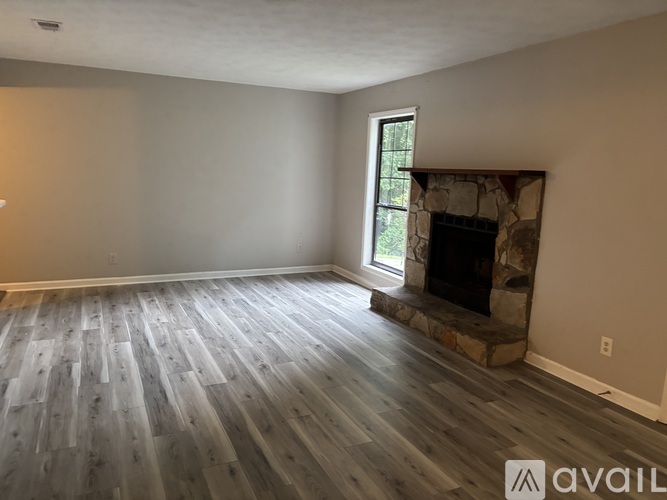 A spacious living room with a fireplace and large windows.