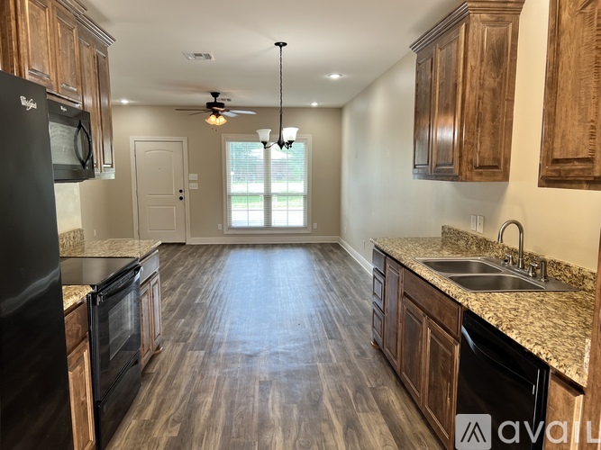 A kitchen with wooden cabinets and a black refrigerator.