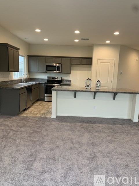 A kitchen with dark brown cabinets and a white countertop.