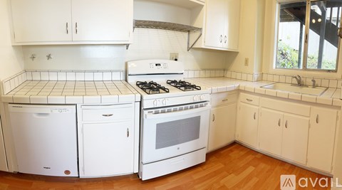 A kitchen with white appliances and cabinets.
