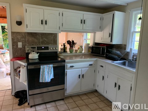 A kitchen with white cabinets and a black oven.