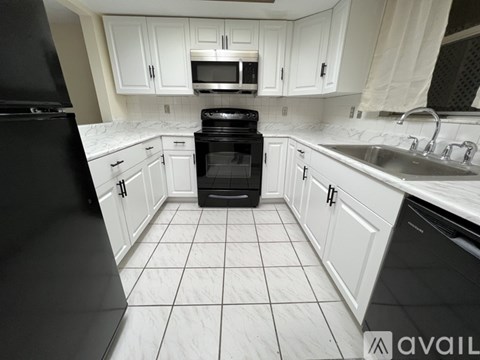 A black oven in a white kitchen.