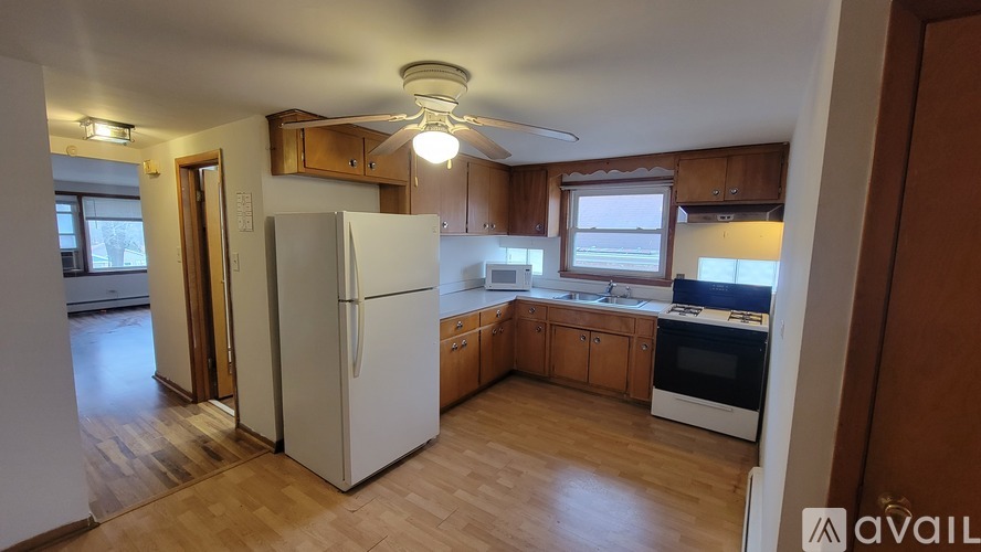 A kitchen with wooden floors and white appliances.