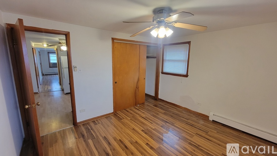 A room with wooden floors and a ceiling fan.