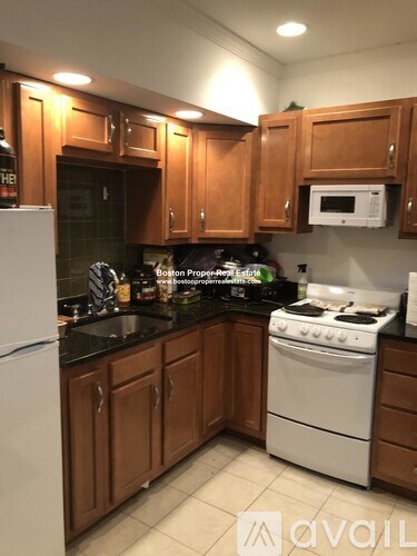 A kitchen with wooden cabinets and a white stove.