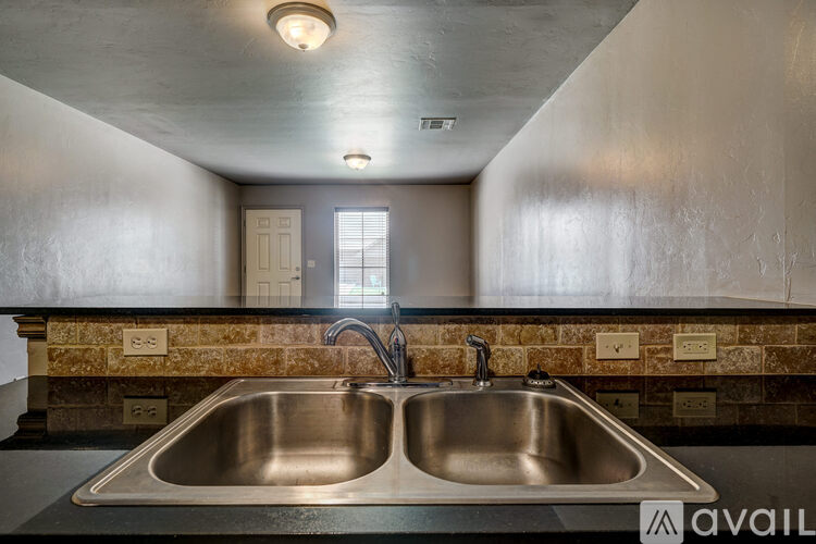 A kitchen with a double sink and a window.