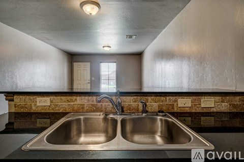 A kitchen with a double sink and a window.