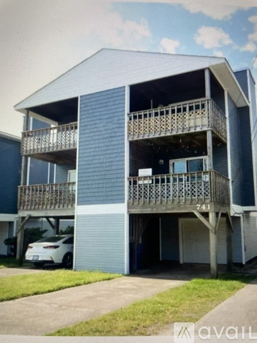 A two-story apartment building with a balcony on the second floor.