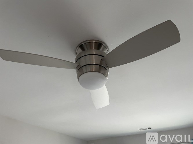 A ceiling fan with a light fixture is mounted on a white ceiling.